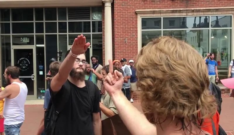 Counterprotester giving one attendee the finger is given a Nazi salute in response. © cc 2.0 File:Nazi Salute