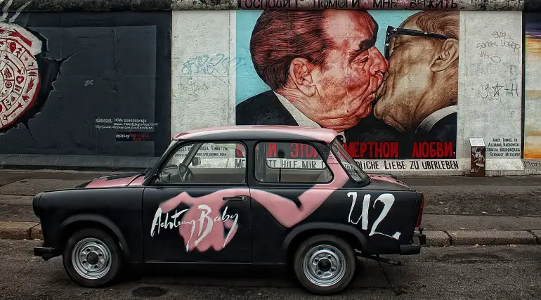 The mortal kiss, © PeterDargatz / Pixabay licence https://pixabay.com/it/photos/muro-di-berlino-auto-graffiti-50727/