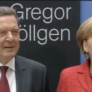 Angela Merkel e Gerhard Schröder - Screenshot da YouTube https://www.youtube.com/watch?v=N1lxSmuNqQs